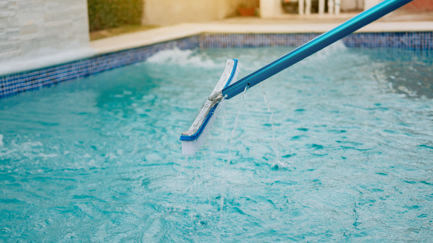 A pool cleaning brush in the middle of a pool