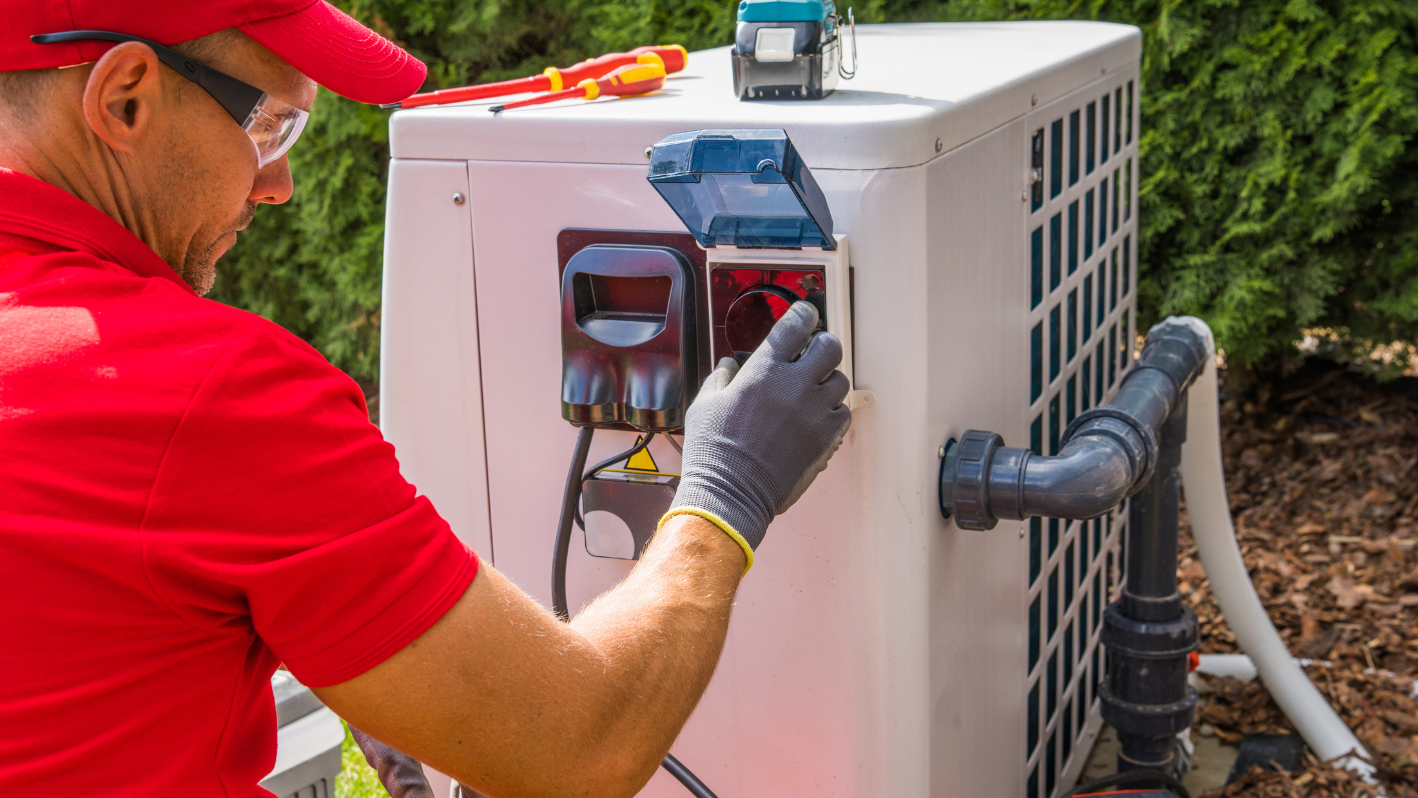 A man in a red shirt is working on an air conditioner